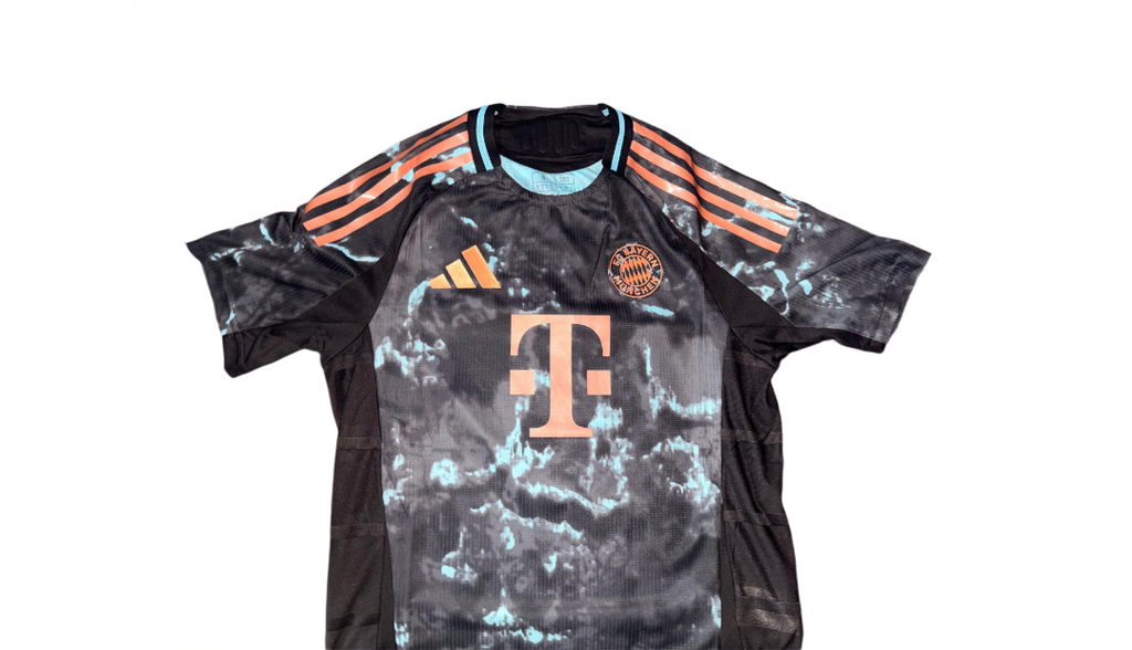 Black sports jersey with orange accents and a logo on a white background